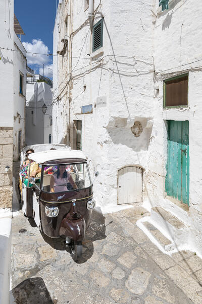Traditional italian taxi through the narrow alleys in the white village of Ostuni (province of Brindisi, Salento, Apulia, Italy)