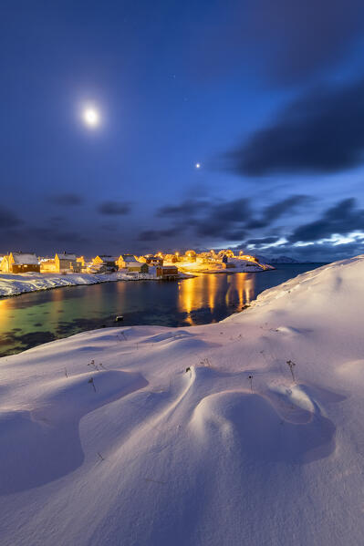 Coastal village of Sorvaer covered with snow during twilight in the cold arctic winter (Soroya Island, Hasvik, Troms og Finnmark, Norway)