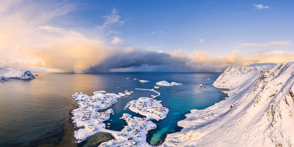 Coastal village of Sorvaer covered with snow during sunrise in the cold arctic winter (Soroya Island, Hasvik, Troms og Finnmark, Norway)