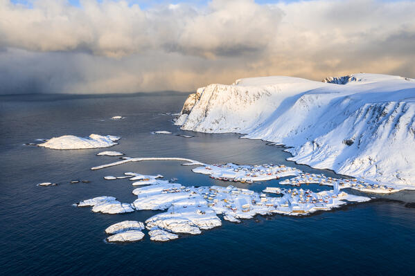 Coastal village of Sorvaer covered with snow during sunrise in the cold arctic winter (Soroya Island, Hasvik, Troms og Finnmark, Norway)
