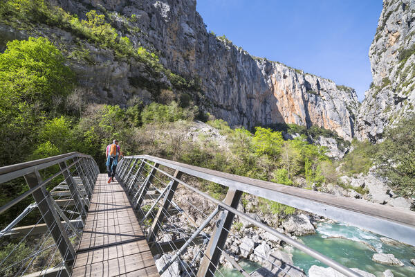 A male climber is crossing the Verdon river on the Estellié Bridge in the Verdon Gorge (Var department, Provence-Alpes-Côte d'Azur, France, Europe)