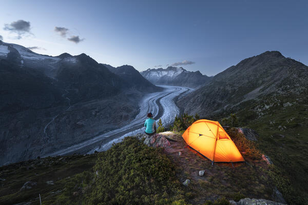 A woman admires the Aletsch Glacier at dusk (Riederalp, Bernese Alps, Canton of Valais, Switzerland, Europe) (MR)