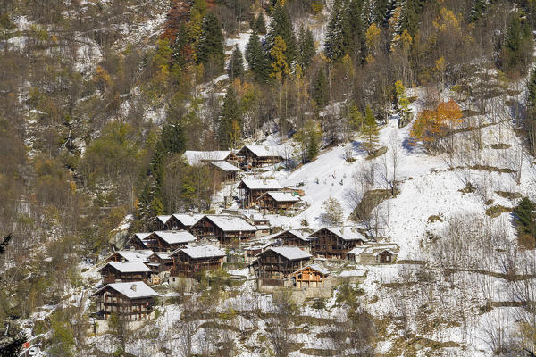 An hamlet near Alagna, a small village at the foot of Monte Rosa, during a cold autumn: the first snow coveres the lodges and the colored trees. (Alagna Valsesia, Valsesia, Vercelli province, Piedmont, Italy, Europe)