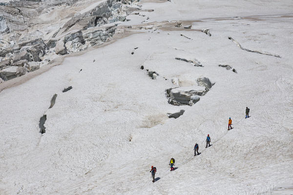 Mountaineers walk on Lys glacier near the Gnifetti refuge in Monte Rosa Massif (Gressoney, Lys Valley; Aosta province, Aosta Valley, Italy, Europe)