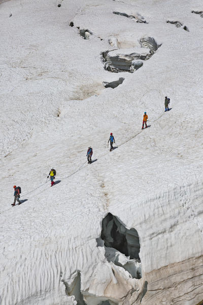 Mountaineers walk on Lys glacier near the Gnifetti refuge in Monte Rosa Massif (Gressoney, Lys Valley; Aosta province, Aosta Valley, Italy, Europe)