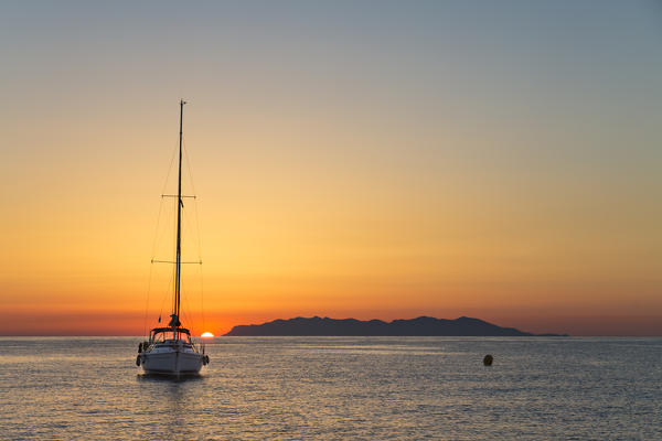 Sailing boat at sunrise, on background Capraia Island (Macinaggio, Rogliano, Bastia, Haute-Corse department, Corsica, France, Europe)