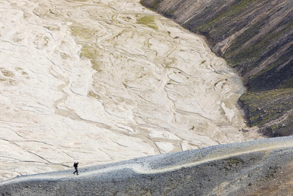 A trekker is walking to the summit of Blahnukur mountain (Landmannalaugar, Fjallabak Nature Reserve, Highlands, Southern Region, Iceland, Europe)