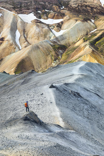 A trekker is looking at the Landmannalaugar panorama from Blahnukur mountain (Landmannalaugar, Fjallabak Nature Reserve, Highlands, Southern Region, Iceland, Europe) (MR)