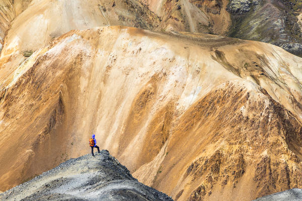 A trekker is looking at the Landmannalaugar panorama from Blahnukur mountain (Landmannalaugar, Fjallabak Nature Reserve, Highlands, Southern Region, Iceland, Europe) (MR)