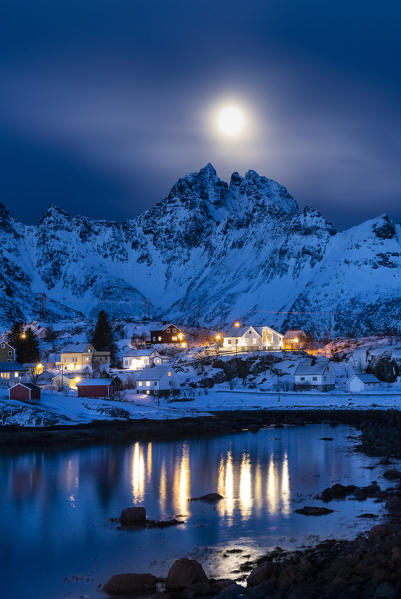 The small village of A, the lasf of Lofoten island by night. With moonlight and mountain peaks in background. A, Lofoten Island, Norway, Scandinavia, Europe.