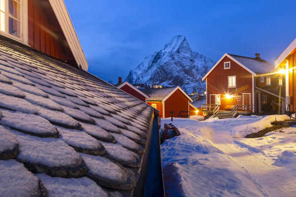 Reine village with red houses and Olstind peak in the background during a winter dusk. Reine, Lofoten island, Norway, Scandinavia, Europe.