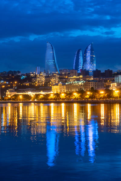 Flame towers cityscape at dusk from Caspian seafront. Baku, Azerbaijan, Central Asia.
