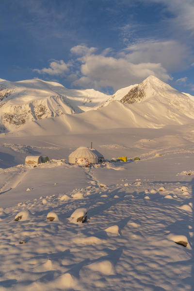 Yurt and tents at camp one of Lenin peak with snow. Peak Lenin base camp, Pamir, Kyrgyzstan, Central Asia.
