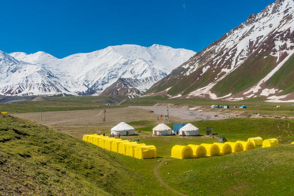 The tents of peak Lenin base camp with Lenin peak in the background. Pamir, Kyrgyzstan, Central Asia. 