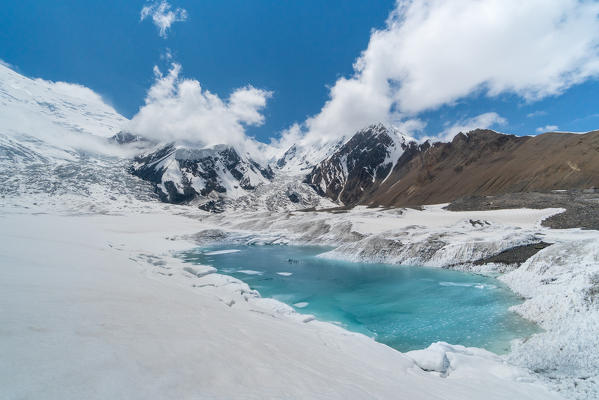 Glacier lake at the base of Peak Lenin mount during early summer. Peak Lenin camp one, Pamir, Kyrgyzstan, Central Asia. 