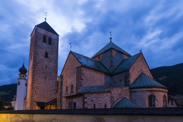 The medioeval Collegiata dei Santi Candido and Corbiniano church in the alpine village of San Candido village during twilight. San Candido, Pusteria valley, Bolzano district, Dolomites, Trentino Alto Adige, Italy, Europe. 