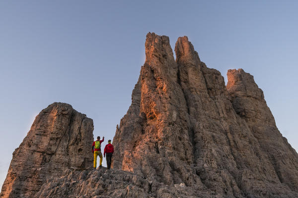 Climbers under Vajolet towers at sunset in Catinaccio group of Dolomites. Re Alberto refuge in Catinaccio group. Gardeccia, Pozza di Fassa, Fassa valley, Trento district, Dolomites, Trentino Alto Adige, Italy, Europe.