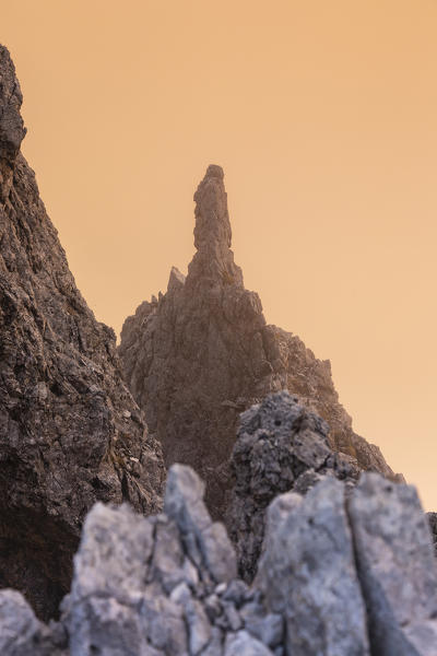 Rock spur with red clouds in background under Roda de Vael mount in Catinaccio group. Carezza, Fassa valley, Trento district, Dolomites, Trentino Alto Adige, Italy, Europe.