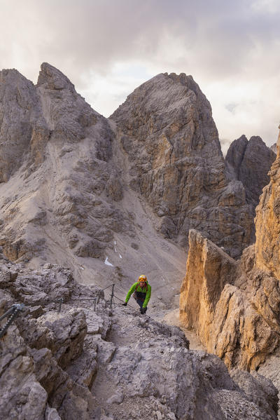 Hiker along railway of Catinaccio di Antermoia in Dolomites. Pozza di Fassa, Fassa valley, Trento district, Dolomites, Trentino Alto Adige, Italy, Europe.
