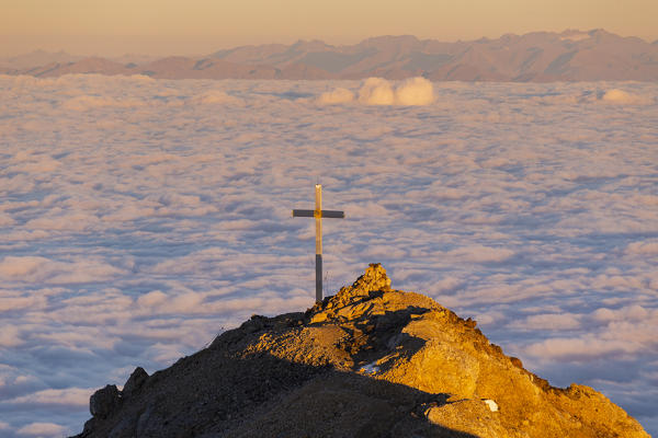 Latemar mount summit during a summer sunrise over a cloudy carpet. Latemar group, Costalunga pass, Fassa valley, Pozza di Fassa, Trento district, Dolomites, Italy, Europe.