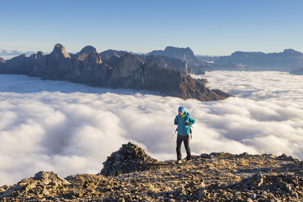 Hiker walking to Latemar mount during a summer sunrise in DOlomites. Latemar group, Costalunga pass, Fassa valley, Pozza di Fassa, Trento district, Dolomites, Italy, Europe.