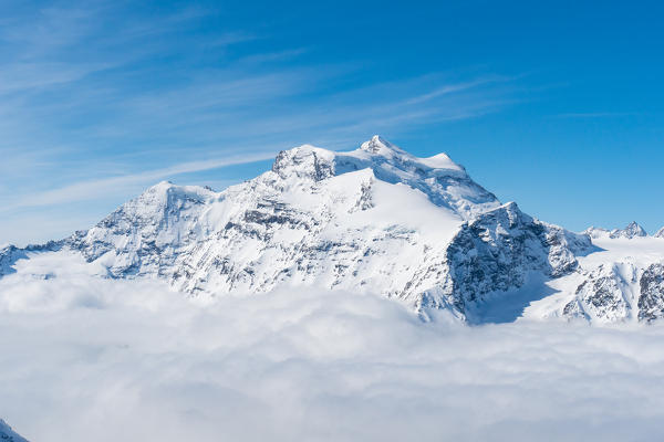 Grand Combin peak over a clouy carpet after a winter snowfall . Igloo refuge des Pantalons Blancs, Heremence, Sion, Valais canton, Switzerland, Europe.