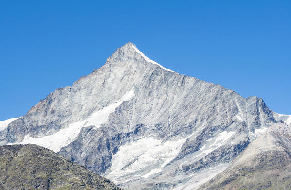 The East rock face of Weisshorn over Zermatt valley during summer. Zermatt, Vallese canton, Switzerland, Alps, Europe. 