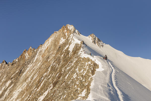 Alpinists along normal route to Nadelhorn, a 4000 peak in Sass Fe valley. Sass Fe, Vallese canton, Switzerland, Alps, Europe.