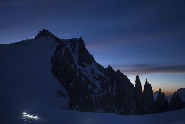 Ski mountaneers during night ascent at mont Blanc along Trois Mont Blanc way. Chamonix, France, Italy