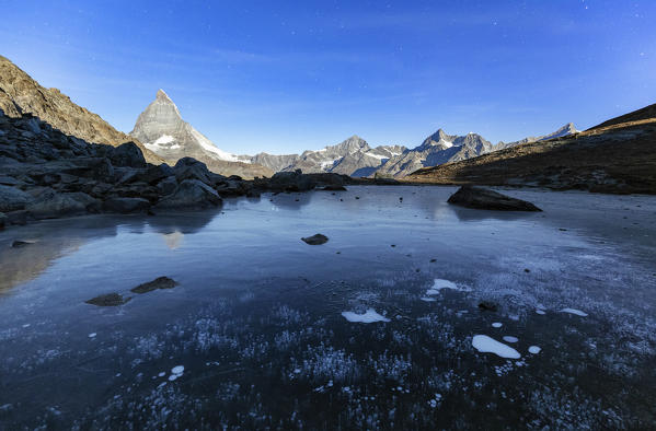 Iced Riffelsee Lake during a full moon night. Zermatt, Mattertal, Canton of Valais, Switzerland, Europe