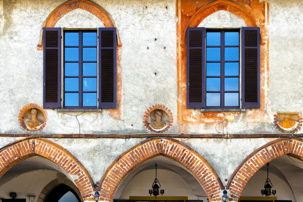 Gothic arches on the facade of the Broletto(courthouse). Arona, Lake Maggiore, Piedmont, Italy, Europe.