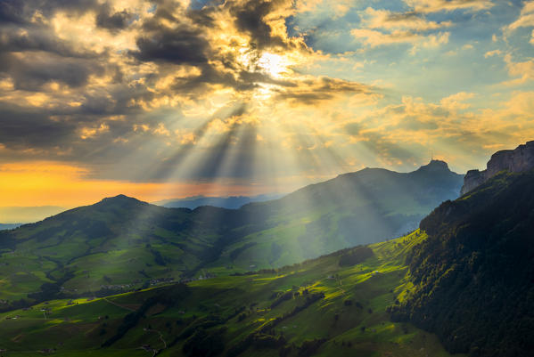 Sun rays filters between clouds at sunrise, Canton of Appenzell, Alpstein, Switzerland, Europe