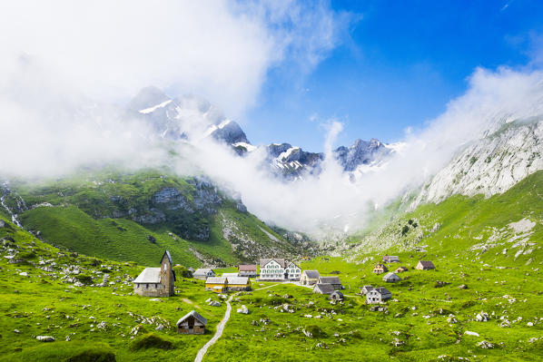 Sunlight filters between fog at the pasture of Meglisalp ,Canton of Appenzell, Alpstein, Switzerland, Europe