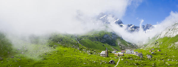 Sunlight filters between fog at the pasture of Meglisalp ,Canton of Appenzell, Alpstein, Switzerland, Europe