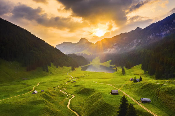 Sun rays filters between clouds at sunrise. Canton of Appenzell, Alpstein, Switzerland, Europe