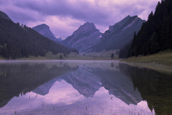 Mountains are reflected in the Samtisersee at sunrise,Canton of Appenzell, Alpstein, Switzerland, Europe