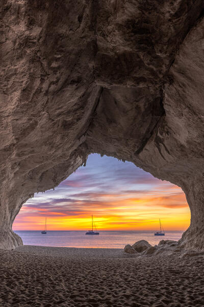 Colors of the sunrise inside the sea cave on the beach of Cala Luna, Baunei, Ogliastra province,  Sardinia, Italy, Europe