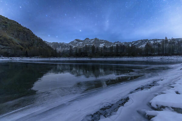 Night view of the frozen Lagazzuolo lake.  Valtellina,Valmalenco, Lombardy, Italy, Europe.