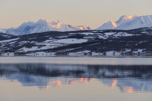 Lyngen Alps are reflected in Balsfjorden during a artic sunrise. Markenes, Balsfjorden, Lyngen Alps, Troms, Norway, Lapland, Europe.