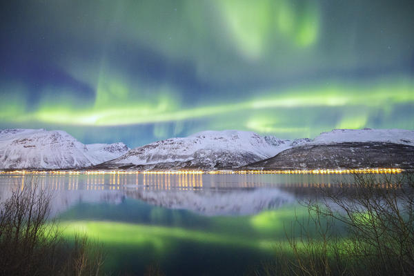 Northern Lights is reflected in Kafjorden. Kafjorden, Lyngen Alps, Troms, Norway, Lapland, Europe.