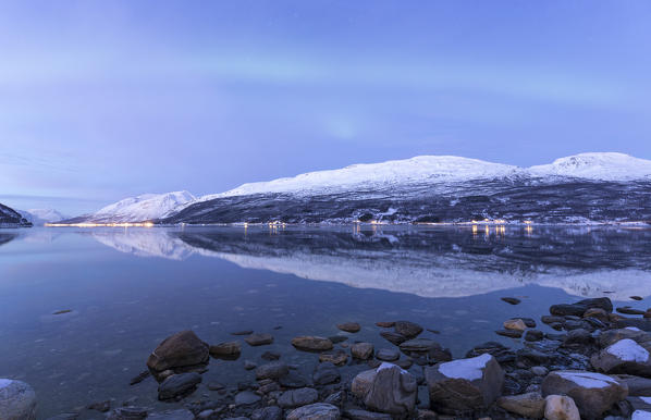The Northern Lights appear in the sky during twilight. Skarvdalen, Kafjord, Lyngen Alps, Troms, Norway, Lapland, Europe.