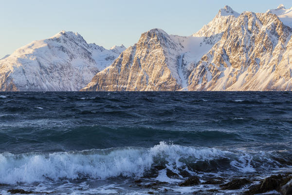 The waves breaking on the windy coast. Spaknesora naturreservat, Djupvik, Lyngenfjord, Lyngen Alps, Troms, Norway, Lapland, Europe.