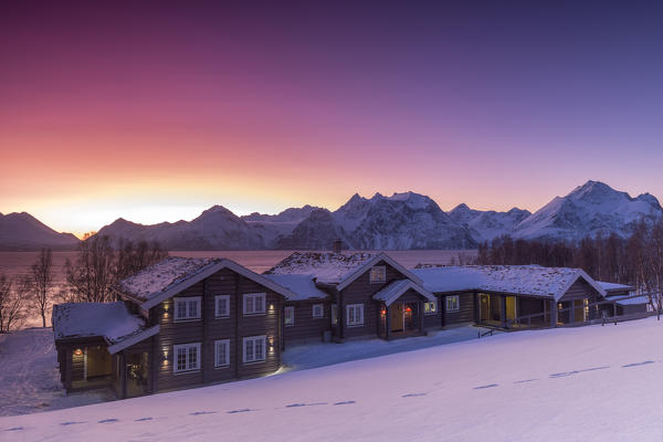 Lyngen Lodge illuminated by the light of the Arctic sunset. Hammarvika, Lyngenfjord, Lyngen Alps, Troms, Norway, Lapland, Europe.