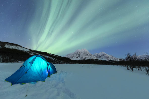 Camping with tent during a night with the Northern Lights. Svensby, Ullsfjorden, Lyngen Alps, Troms, Norway, Lapland, Europe.