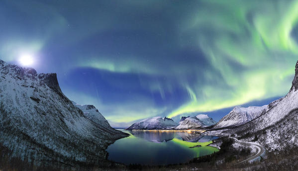 Northern lights in the night sky illuminates by moon from panoramic point over Bergsfjorden. Bergsfjorden, Senja, Norway, Europe.