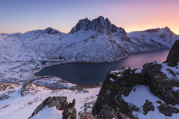 Mefjorden and Breidtinden illuminated by the colors of the arctic sunset. Barden, Mefjordbotn, Mefjorden, Senja, Norway, Europe.