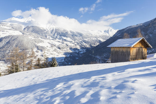 A typical Tyrolean hut overlooks the snow-covered Kaunertal. Ladis, Inntal, Tirol, Osterreich, Europe