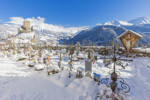 Ladis cemetery with the castle behind. In the background view of Kaunertal. Ladis, Inntal, Tirol, Osterreich, Europe