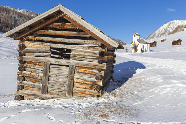 Typical wind-sloping walser hut with the church of the highland behind it. Pfunds Tschey, Pfunds, Inntal, Tirol, Osterreich, Europe
