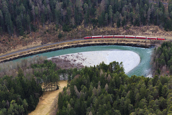 The red train travels along the Rhine River which over the centuries has carved a deep ravine. Rhein Gorge(Ruinaulta), Flims, Imboden, Graubunden, Switzerland, Europe